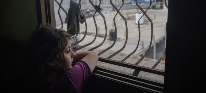 UNICEF/Eyad El Baba Niña palestina mira por la ventana en la Franja de Gaza.